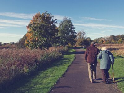 Elderly couple walking on a park path in Surrey